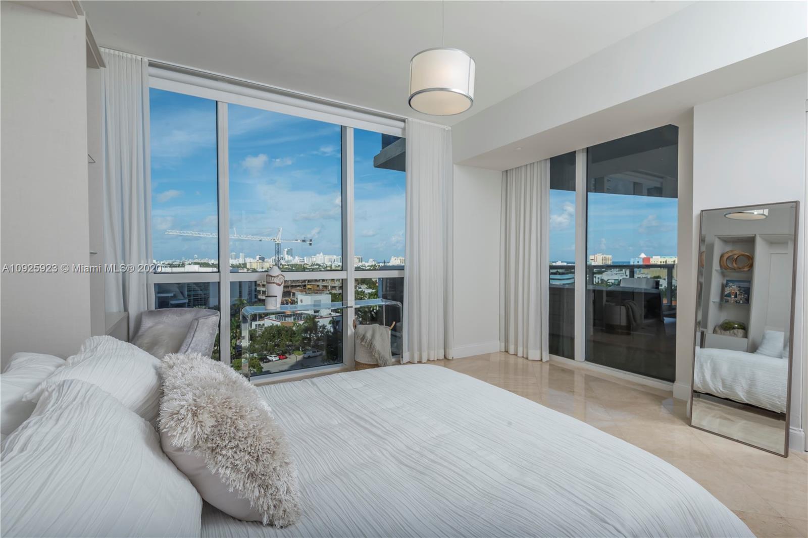 400 Alton Road, Unit 1007 Miami Beach, FL 33139 - Photo 10 of 13 a bedroom with a bed and a large window