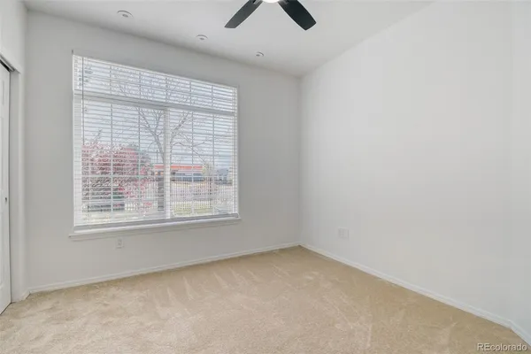 an empty room with a window and a ceiling fan