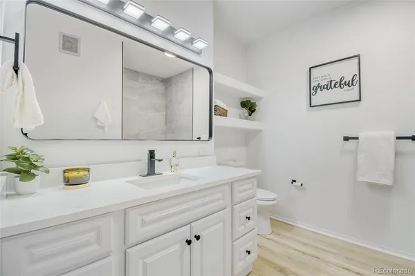 a bathroom with a sink a toilet and mirror