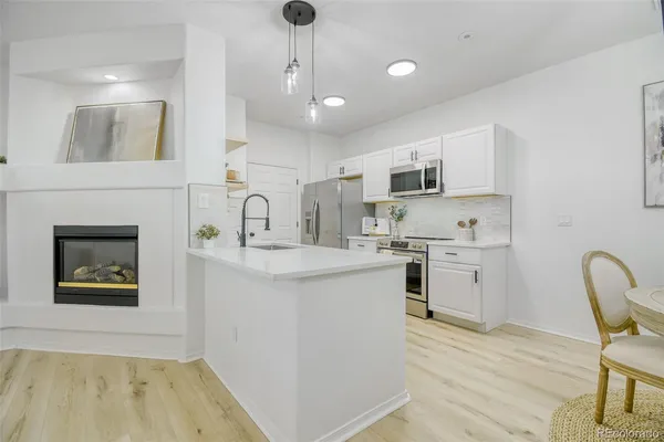 a kitchen with a sink cabinets and wooden floor
