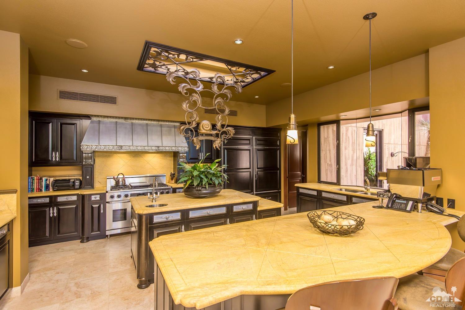 70416 Placerville Road Rancho Mirage, CA 92270 - Photo 14 of 32 a kitchen with stainless steel appliances kitchen island granite countertop a stove and a sink