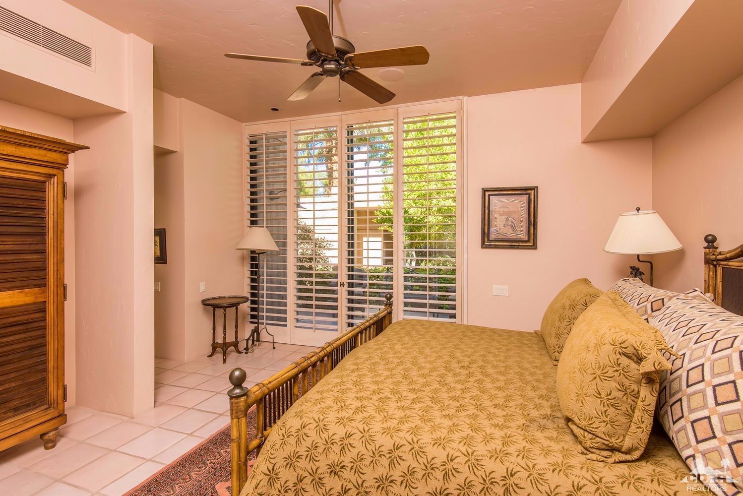 70416 Placerville Road Rancho Mirage, CA 92270 - Photo 23 of 32 a bedroom with a large bed and a chandelier