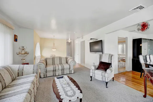 a view of a dining room with furniture a chandelier and large windows