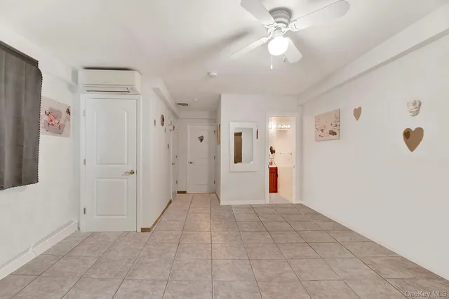 a view of a hallway with closet and a chandelier fan