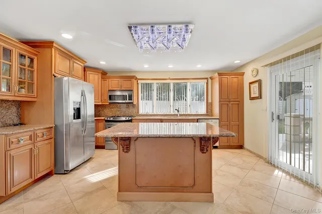a kitchen with stainless steel appliances granite countertop a refrigerator and a stove top oven