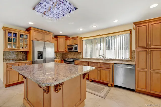a kitchen with stainless steel appliances granite countertop a sink refrigerator and cabinets