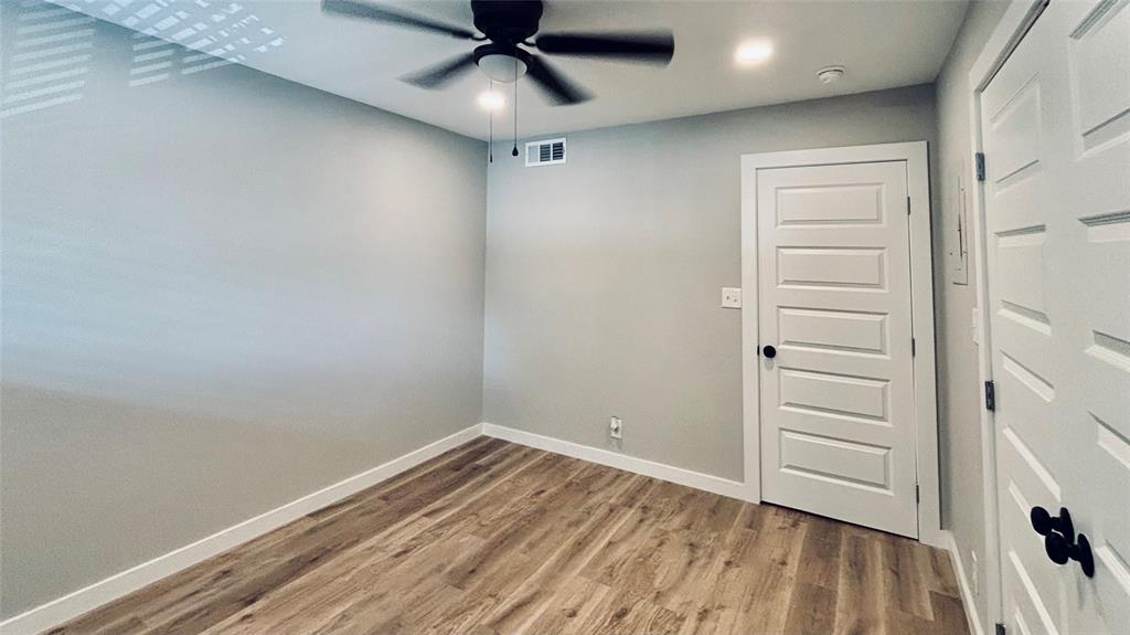 4603 Junius Street, Unit 8 Dallas, TX 75246 - Photo 12 of 15 an empty room with a hardwood and ceiling fan