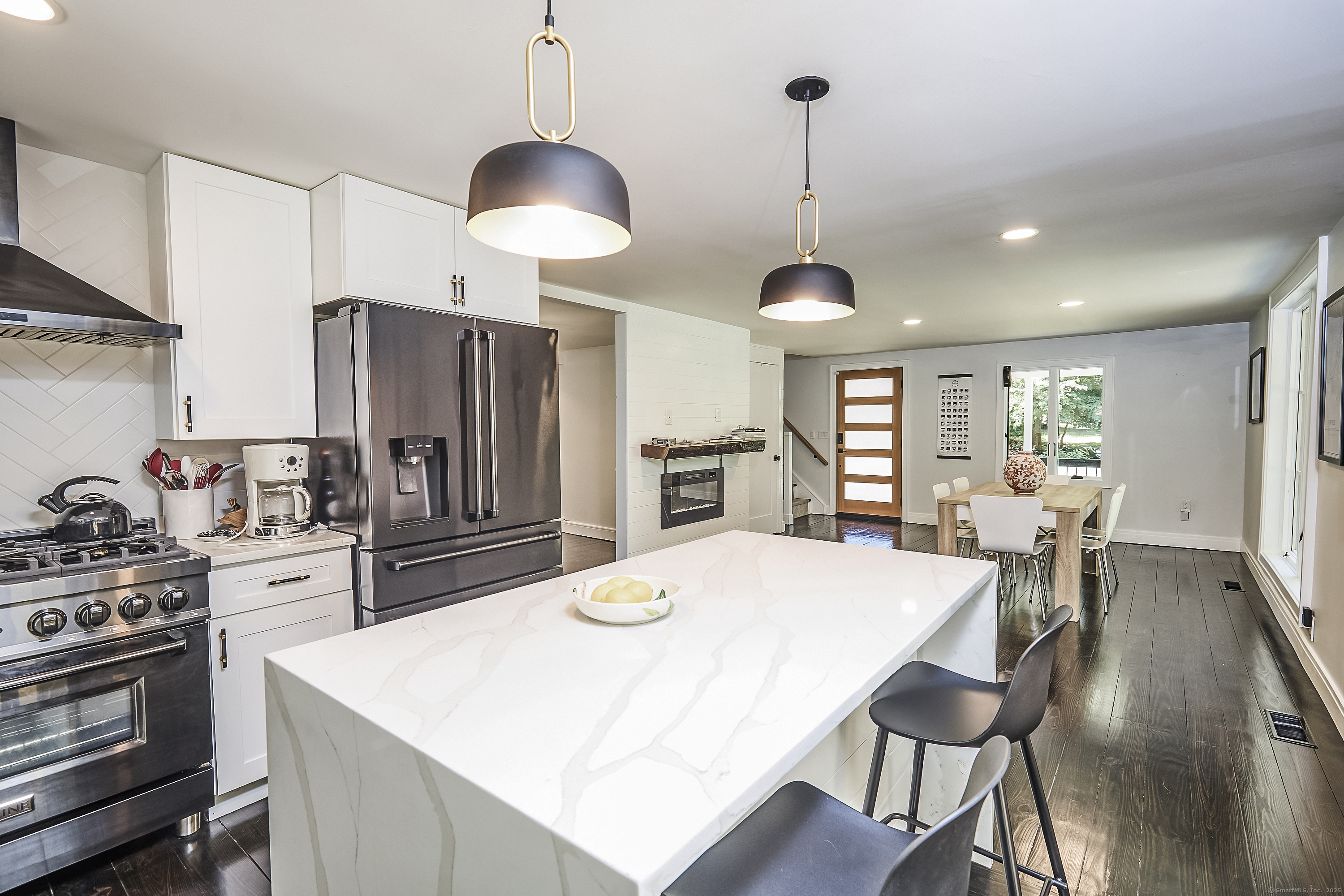 1207 Stillson Road Fairfield, CT 06824 - Photo 16 of 39 a kitchen with stainless steel appliances a dining table chairs stove refrigerator and cabinets