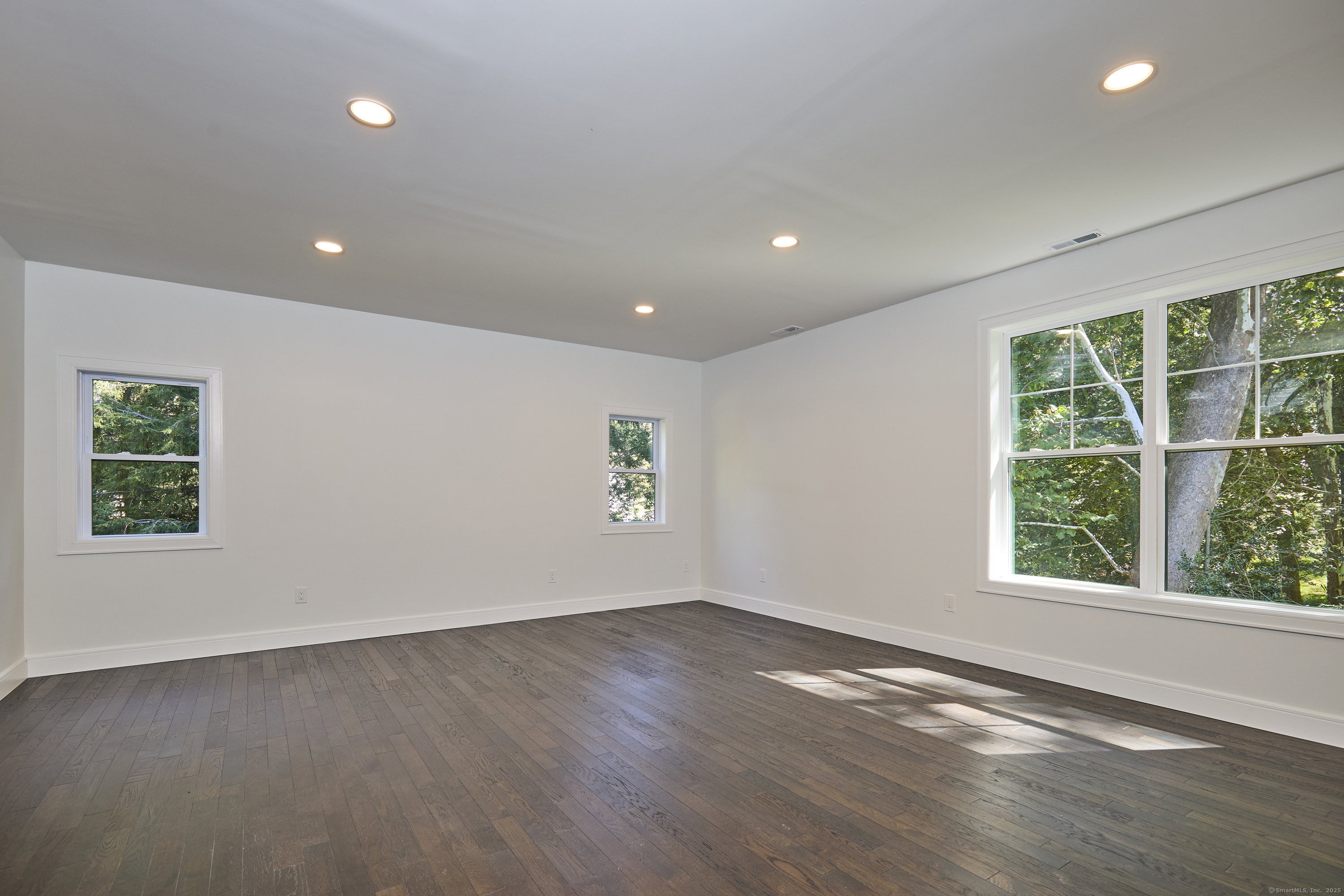 1207 Stillson Road Fairfield, CT 06824 - Photo 29 of 39 an empty room with wooden floor and windows