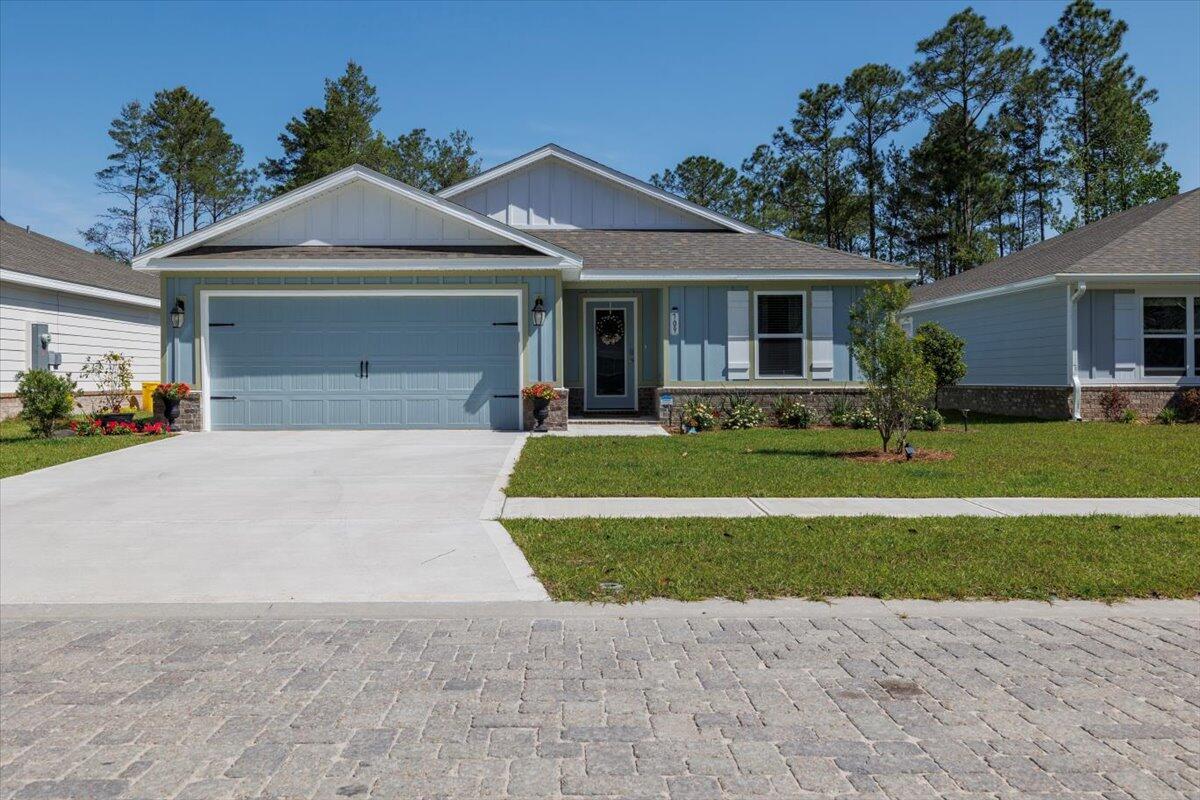 a front view of a house with a garden and trees