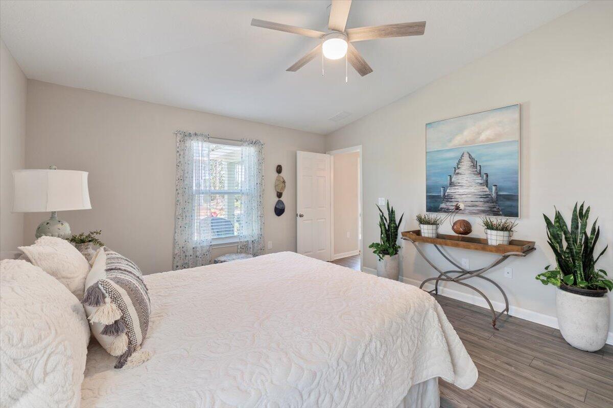 709 Riverwalk Circle Freeport, FL 32439 - Photo 18 of 28 a bedroom with a large bed and a chandelier