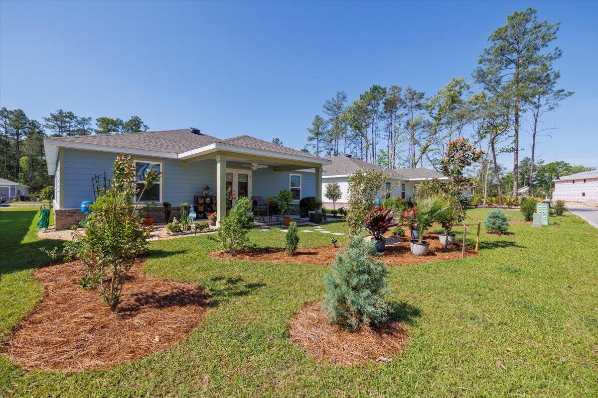 709 Riverwalk Circle Freeport, FL 32439 - Photo 23 of 28 a front view of a house with sitting area and garden