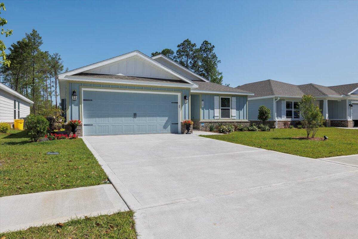 709 Riverwalk Circle Freeport, FL 32439 - Photo 28 of 28 a front view of a house with a yard and garage