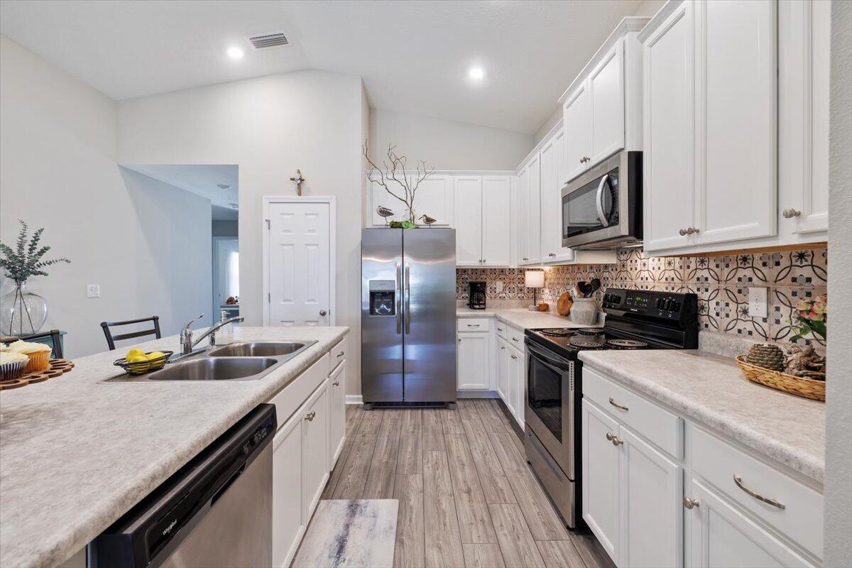 709 Riverwalk Circle Freeport, FL 32439 - Photo 9 of 28 a kitchen with a sink stove and refrigerator