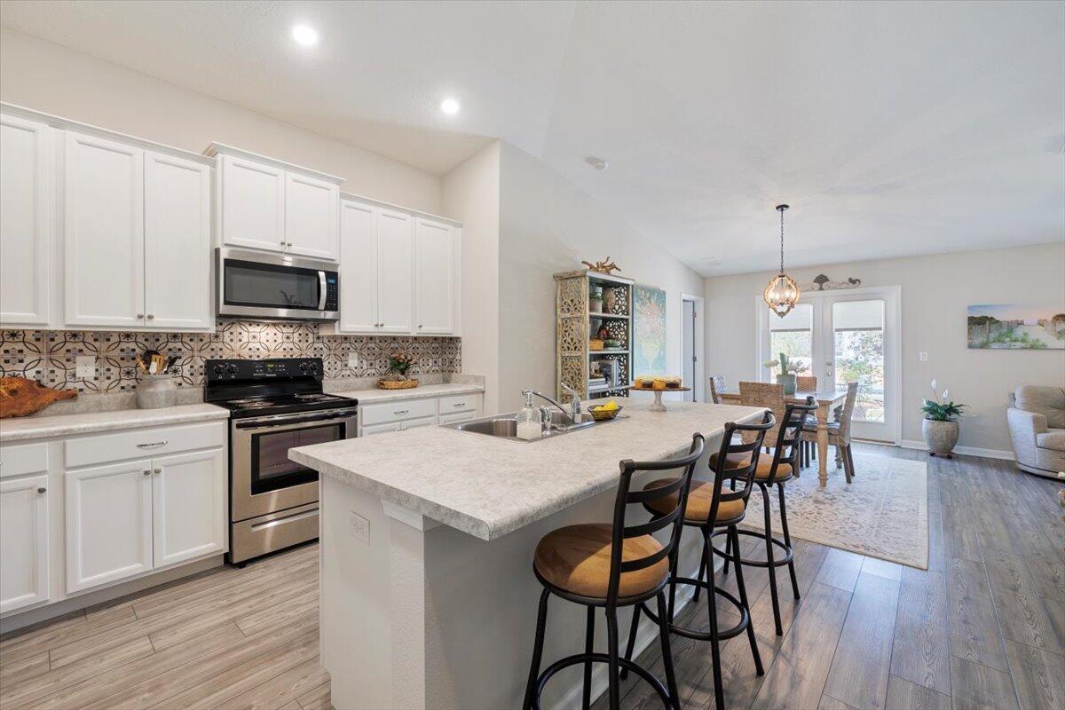 709 Riverwalk Circle Freeport, FL 32439 - Photo 10 of 28 a kitchen with a dining table chairs stove and cabinets