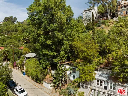 a backyard of a house with lots of green space and fountain in the back