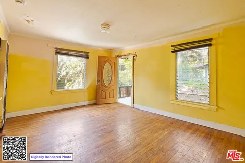 a view of an empty room with a window and wooden floor