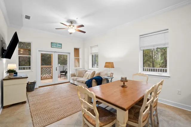 a living room with furniture a flat screen tv and a floor to ceiling window