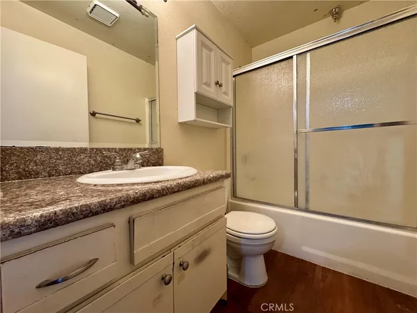 a bathroom with a granite countertop sink toilet and shower