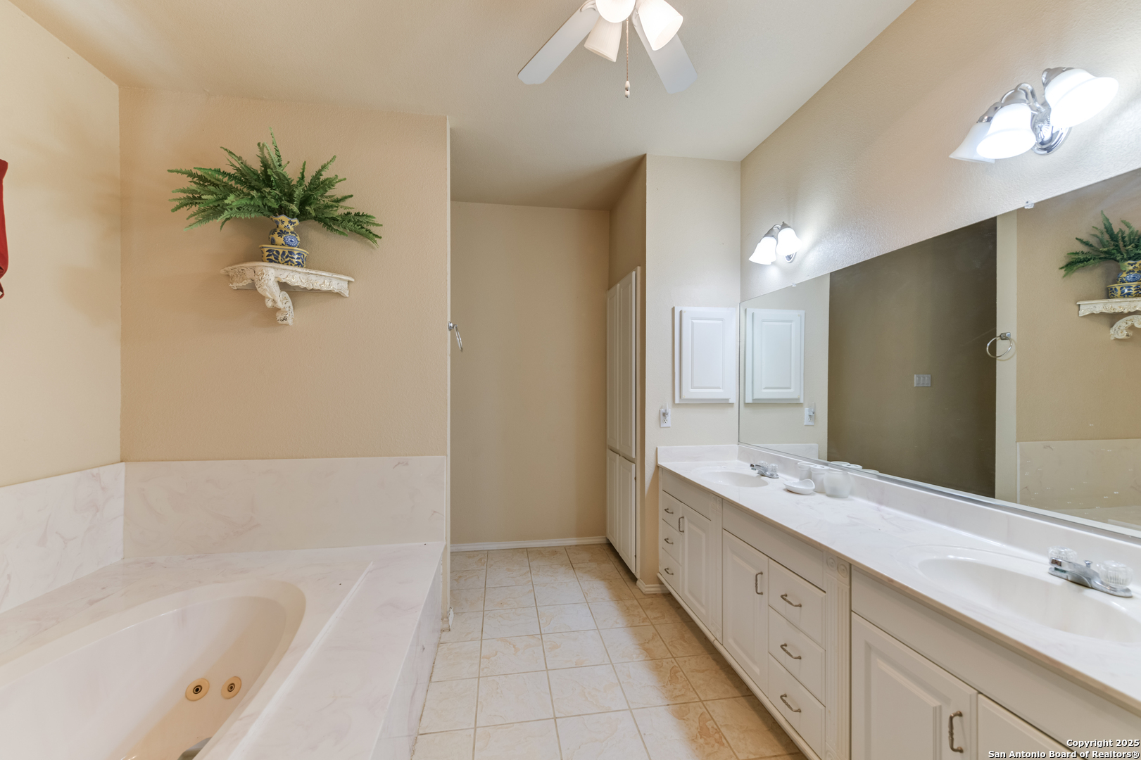 4614 County Road 5232 D'Hanis, TX 78850 - Photo 40 of 40 a bathroom with a double vanity sink a tub and a mirror