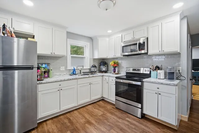 a kitchen with stainless steel appliances granite countertop a refrigerator sink and microwave