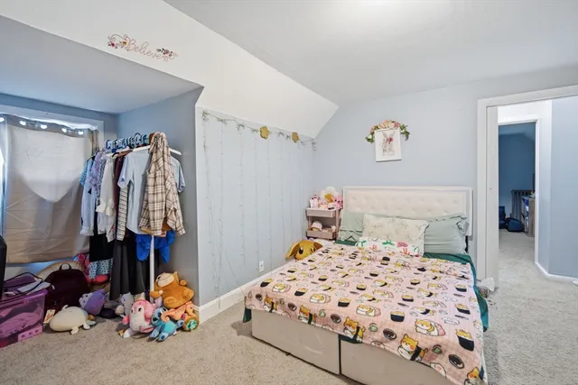 a bedroom with a large bed and a baby crib