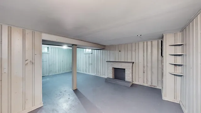 a view of an empty room with a fireplace and a window