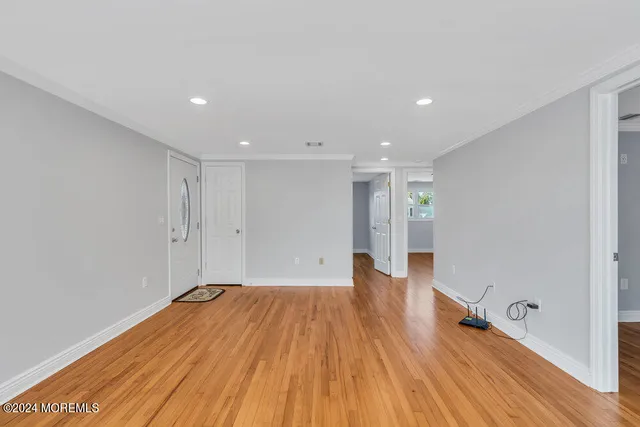 a view of empty room with wooden floor