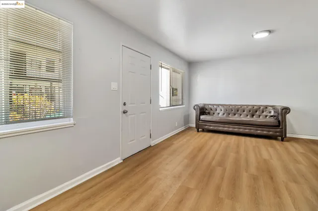 a view of room with wooden floor and windows
