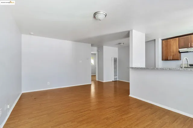 a view of an empty room with wooden floor