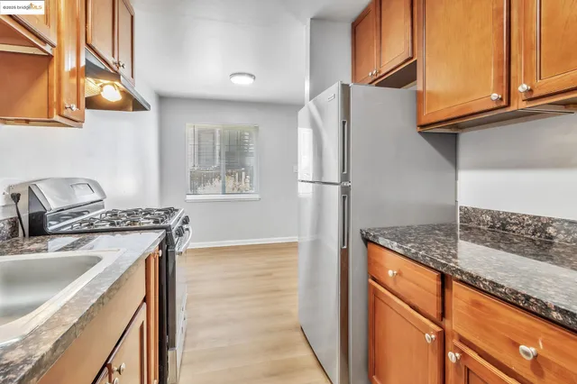 a kitchen with stainless steel appliances granite countertop a sink stove and refrigerator