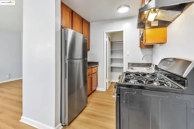 a kitchen with stainless steel appliances granite countertop a refrigerator and a stove