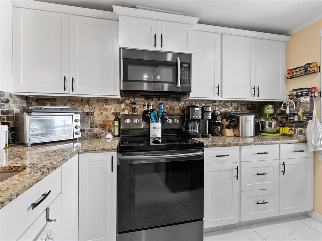 4237 Redcliff Place New Port Richey, FL 34652 - Photo 4 of 25 a kitchen with stainless steel appliances granite countertop a sink and a stove