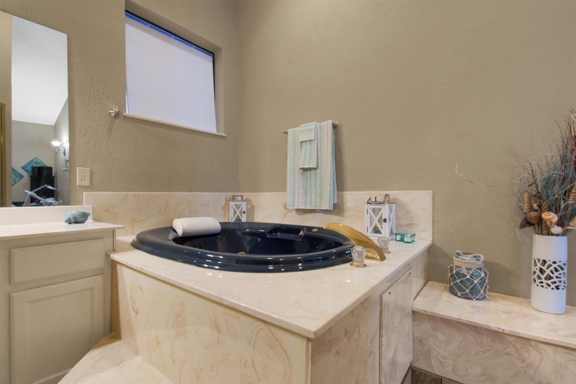 416 Depot Street Elgin, TX 78621 - Photo 17 of 21 Full bathroom featuring a textured wall, a garden tub, and vanity