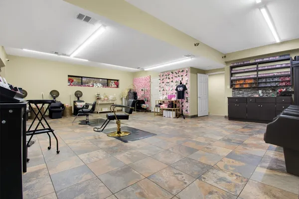 a living room with furniture and a refrigerator