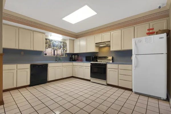 a kitchen with a refrigerator sink and cabinets