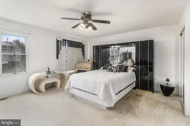 a spacious bedroom with a bed and ceiling fan