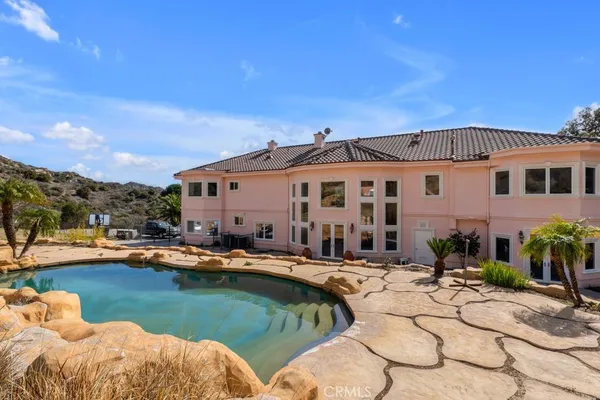 a view of a house with swimming pool and chairs