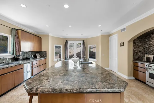 a large kitchen with kitchen island a stove a sink a refrigerator dining table and chairs