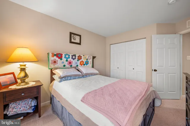 a bedroom with a bed and a lamp on dresser