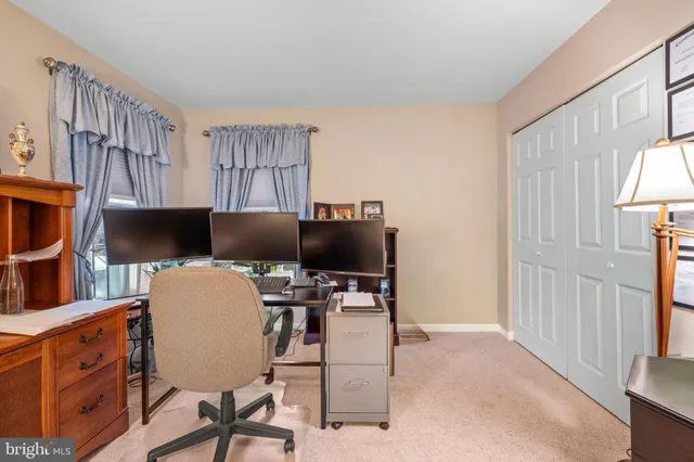 a work room with furniture a flat screen tv and a window