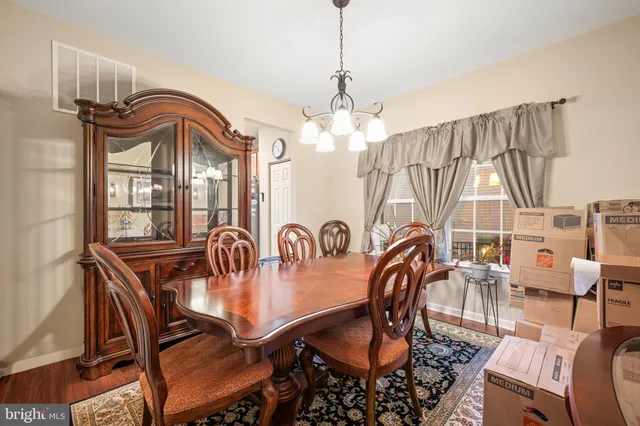 a dining room with furniture a chandelier and wooden floor