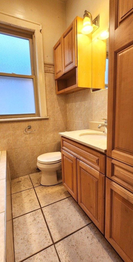 7227 South Bennett Avenue Chicago, IL 60649 - Photo 11 of 47 a bathroom with a granite countertop sink and a mirror