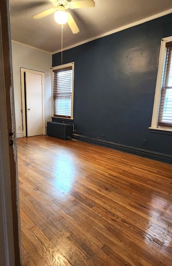 7227 South Bennett Avenue Chicago, IL 60649 - Photo 13 of 47 an empty room with wooden floor and windows