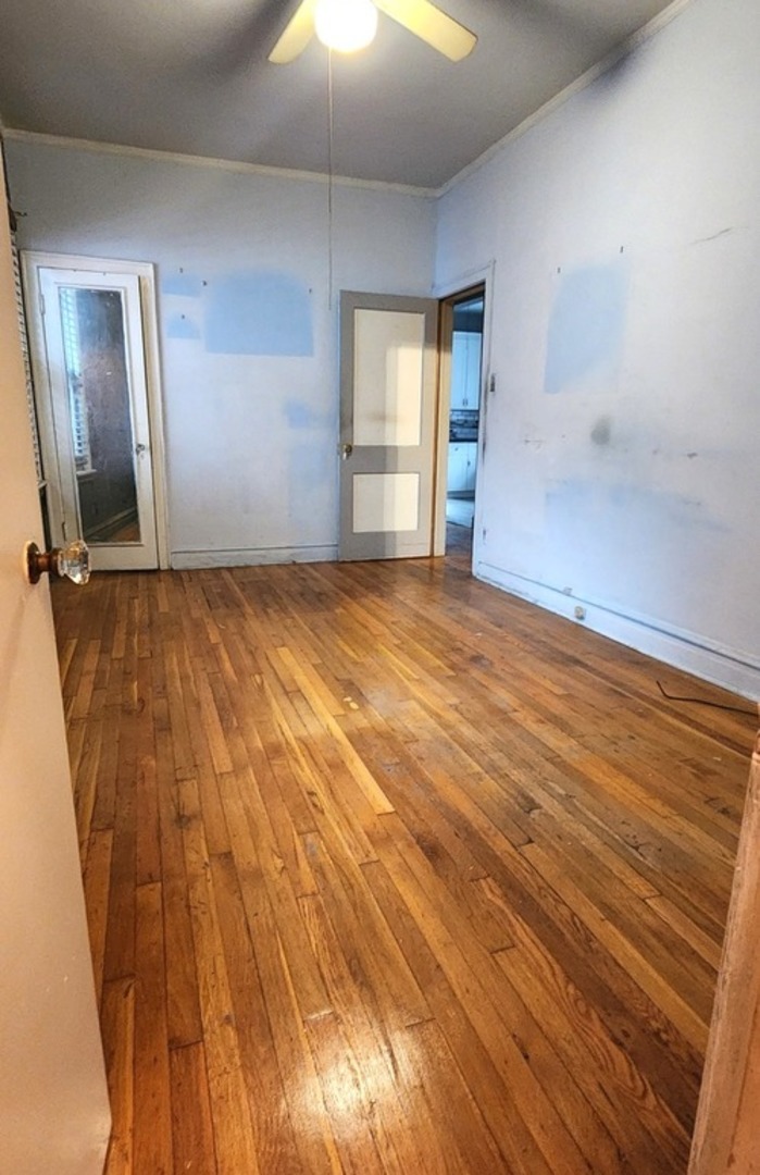 7227 South Bennett Avenue Chicago, IL 60649 - Photo 14 of 47 a view of an empty room with wooden floor and a window