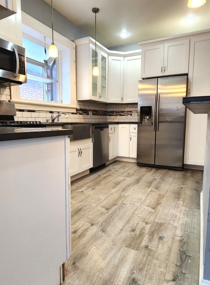 7227 South Bennett Avenue Chicago, IL 60649 - Photo 19 of 47 a kitchen with stainless steel appliances granite countertop a sink a stove and a refrigerator