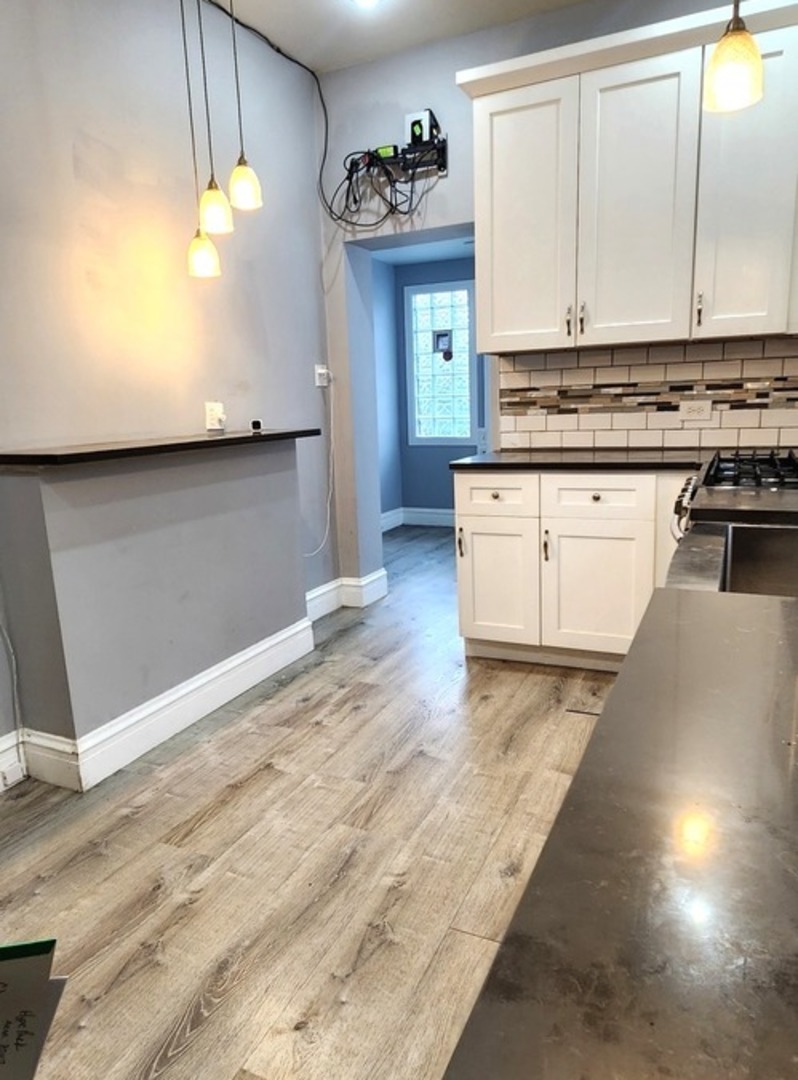 7227 South Bennett Avenue Chicago, IL 60649 - Photo 21 of 47 a kitchen with stainless steel appliances granite countertop a stove a sink and a refrigerator