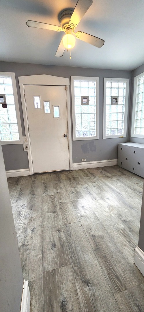 7227 South Bennett Avenue Chicago, IL 60649 - Photo 22 of 47 a view of an empty room with wooden floor and a window