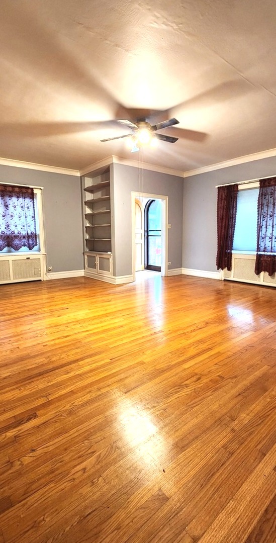 7227 South Bennett Avenue Chicago, IL 60649 - Photo 6 of 47 a view of an empty room with window and wooden floor