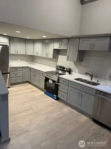 a kitchen with stainless steel appliances granite countertop a stove a sink and a refrigerator